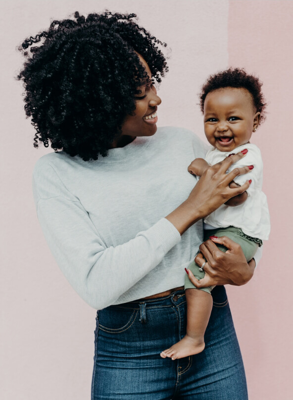 A self-employed mother holds her baby looking at her, while the baby looks at the camera.